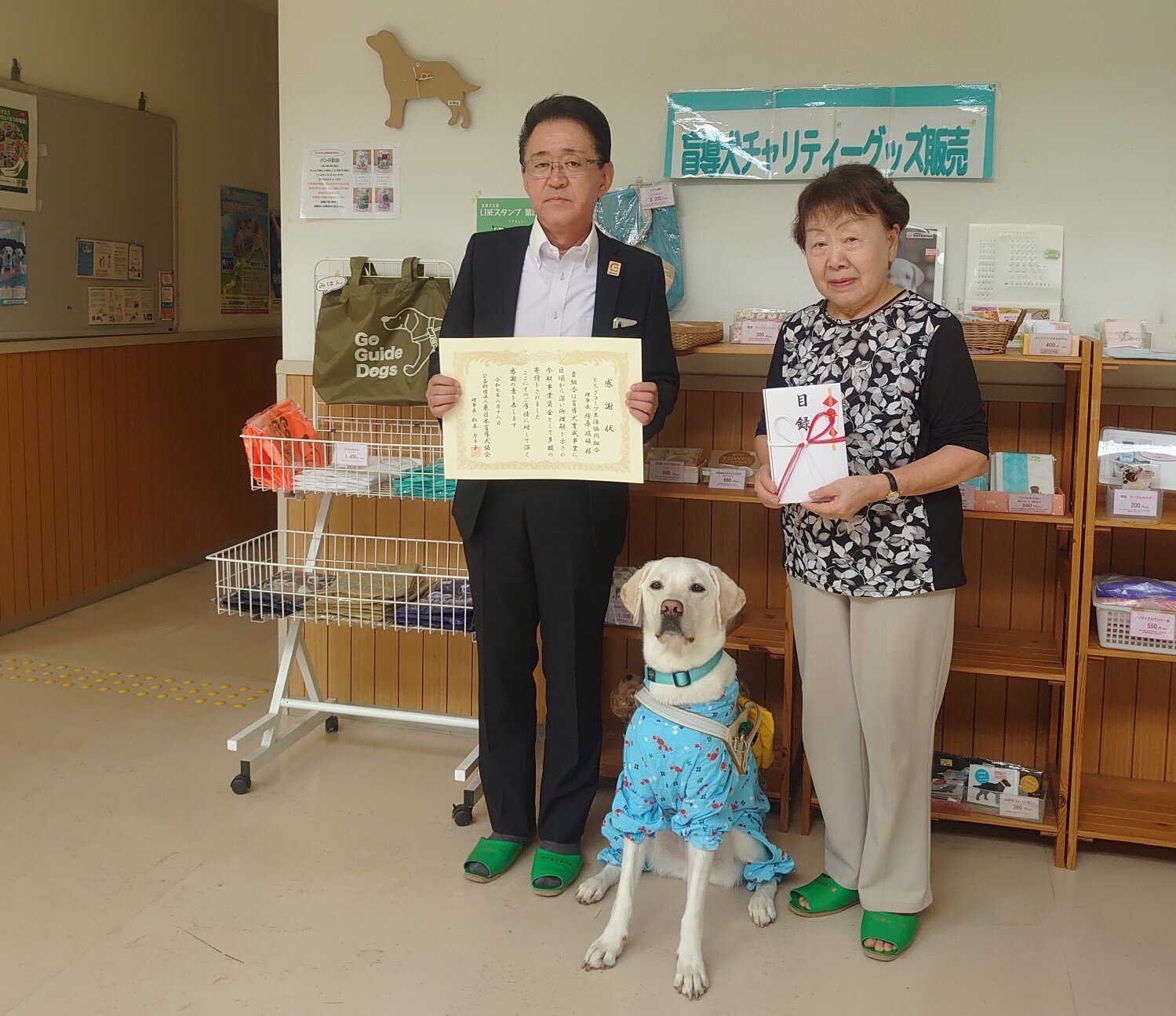 (左側)とちぎコープ理事長 塚原政雄　(右側)東日本盲導犬協会理事長 松本カネ子様 PR犬のIZUMO(イズモ)君 2歳オス
